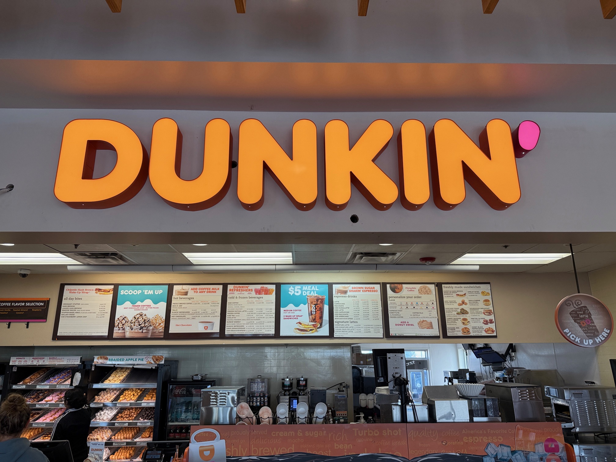 Custom indoor illuminated sign for Dunkin’ showing how branded signage enhances the client experience.