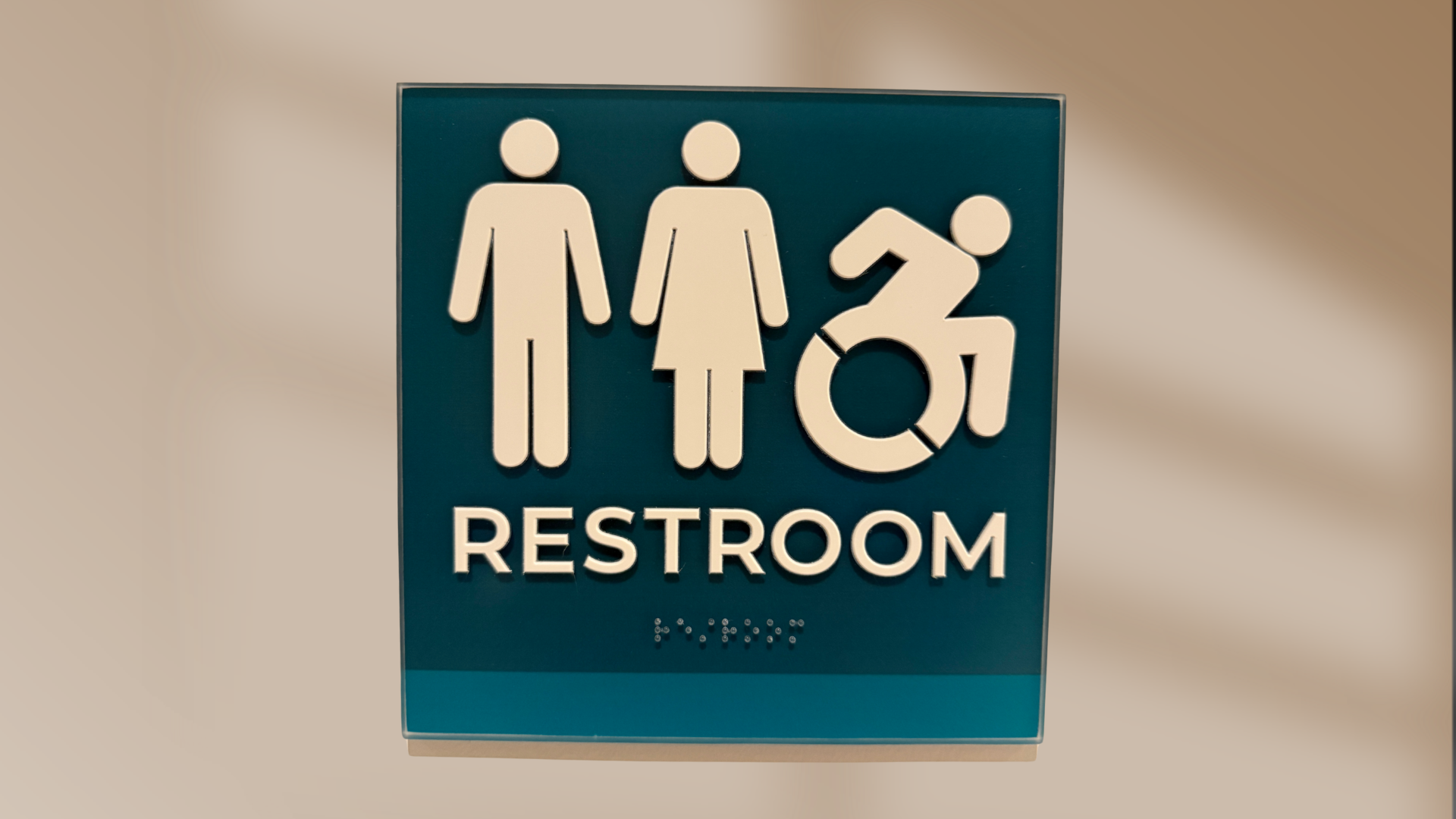 ADA compliant office sign with tactile lettering and braille inside a Denver business.